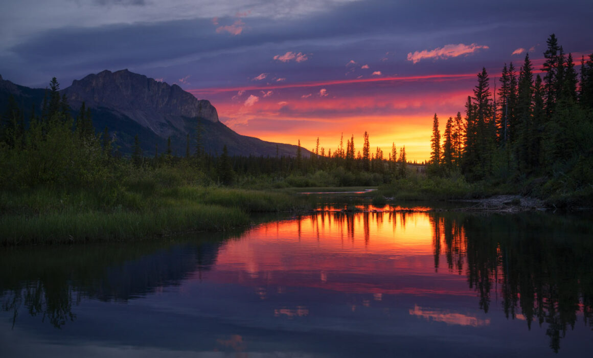 Yamnuska reflected in a small waterway in the pre-dawn light during a spectacular sunrise photographed by Nick Fitzhardinge.